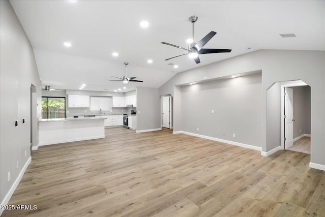 3540 S Cottonwood Dr, Camp Verde, AZ 86322 - unfurnished living room with lofted ceiling, a ceiling fan, recessed lighting, light wood-style flooring, and arched walkways
