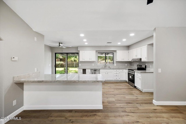 3540 S Cottonwood Dr, Camp Verde, AZ 86322 - kitchen featuring stainless steel appliances, a peninsula, a sink, light stone countertops, and white cabinets