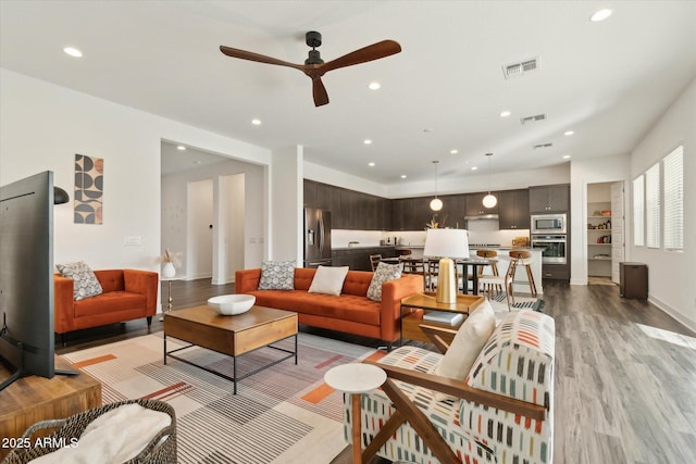 living room with ceiling fan and light wood-type flooring