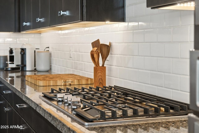 room details featuring tasteful backsplash, stainless steel gas cooktop, and dark stone countertops