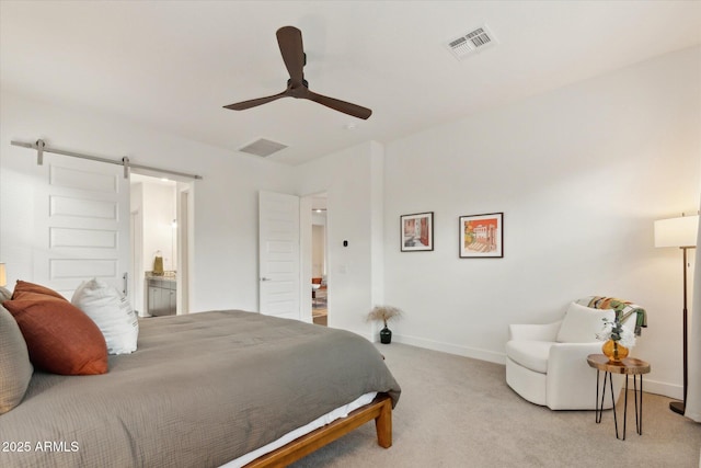 bedroom with light carpet, connected bathroom, a barn door, and ceiling fan