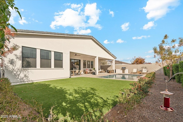 back of house with ceiling fan, a yard, a fenced in pool, and a patio area