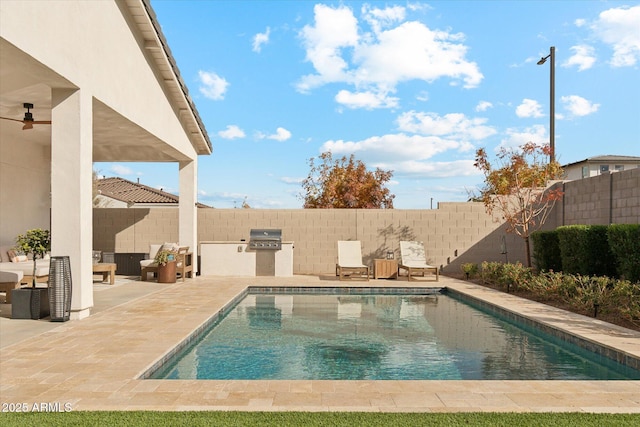 view of swimming pool with ceiling fan, an outdoor kitchen, area for grilling, and a patio