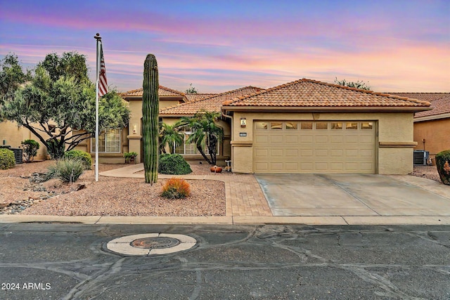 view of front of home featuring cooling unit and a garage