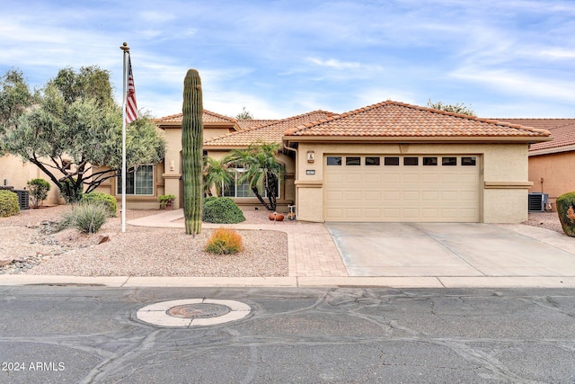 view of front of home featuring central AC and a garage