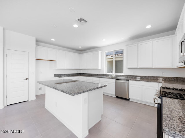 14634 W Sand Hills Rd, Surprise, AZ 85387 - kitchen with appliances with stainless steel finishes, a sink, light tile patterned floors, dark stone countertops, and white cabinetry