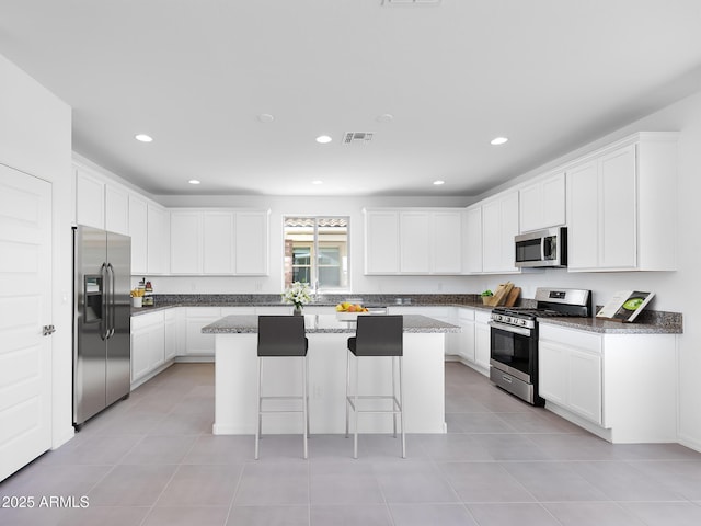 14634 W Sand Hills Rd, Surprise, AZ 85387 - kitchen with stainless steel appliances, a breakfast bar, a center island, recessed lighting, and white cabinetry