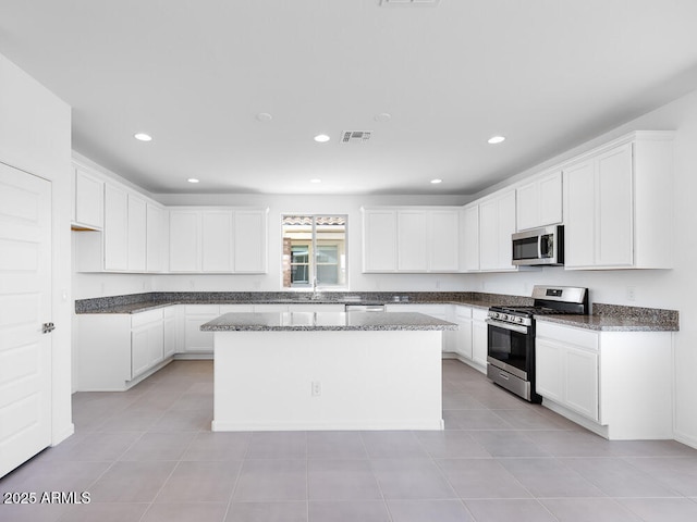 14634 W Sand Hills Rd, Surprise, AZ 85387 - kitchen with appliances with stainless steel finishes, a center island, white cabinetry, recessed lighting, and dark stone counters