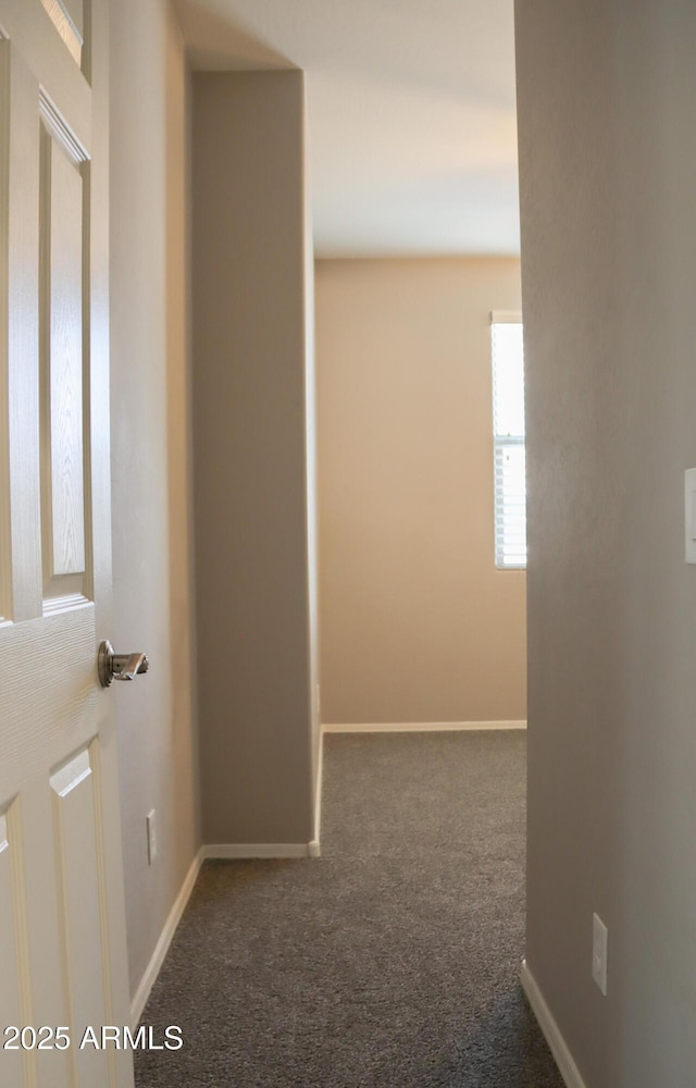 hall featuring carpet and baseboards