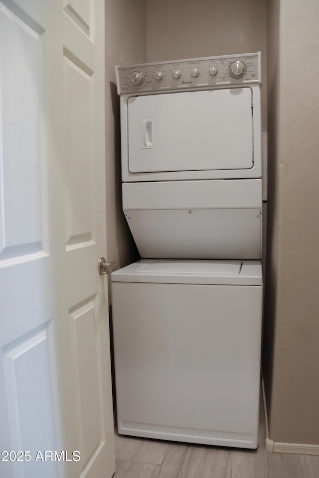 clothes washing area featuring laundry area and stacked washing maching and dryer