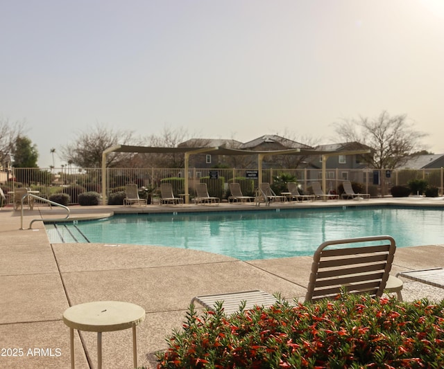 pool with a patio and fence