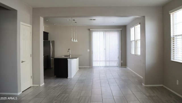 interior space featuring baseboards, visible vents, and freestanding refrigerator