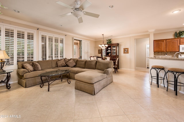 tiled living room featuring ornamental molding, sink, and ceiling fan with notable chandelier