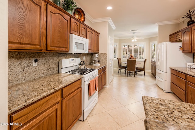 kitchen featuring backsplash, light tile floors, light stone countertops, ceiling fan, and white appliances