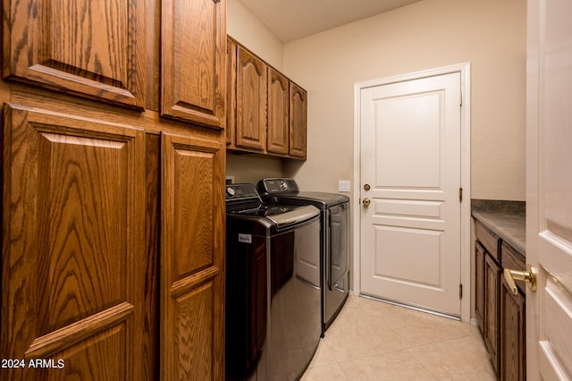 washroom with light tile floors, cabinets, and separate washer and dryer