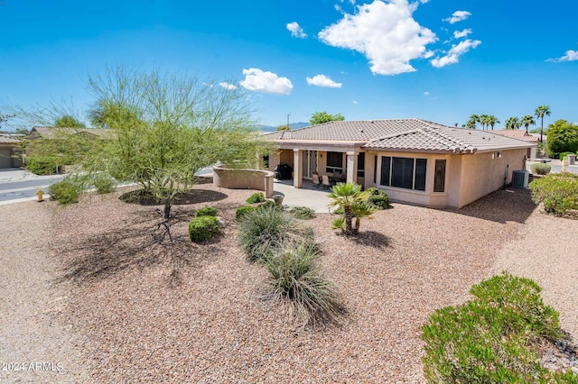 rear view of property with central AC unit and a patio