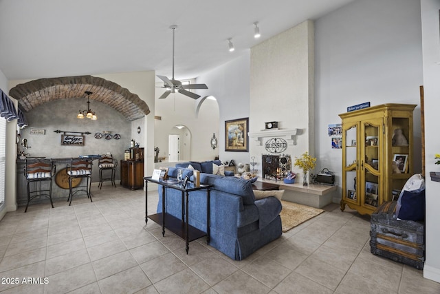 living room featuring high vaulted ceiling, light tile patterned floors, and ceiling fan