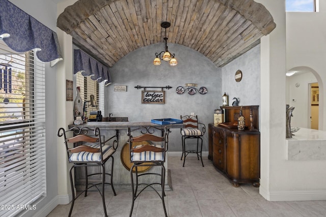 interior space with pendant lighting, light tile patterned floors, vaulted ceiling, and an inviting chandelier