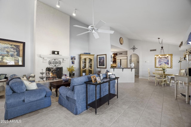 tiled living room with vaulted ceiling and ceiling fan with notable chandelier