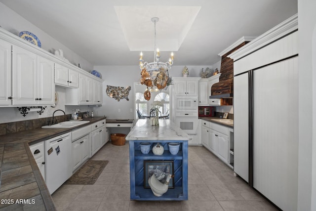 kitchen with sink, decorative light fixtures, a raised ceiling, white appliances, and white cabinets