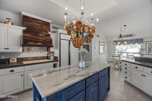 kitchen with white cabinetry, blue cabinets, black electric cooktop, and a notable chandelier