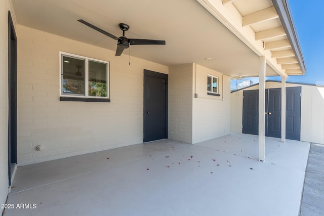 view of patio with a storage shed, a ceiling fan, and an outdoor structure
