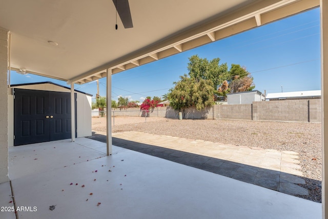 view of patio featuring a fenced backyard, an outbuilding, and a shed