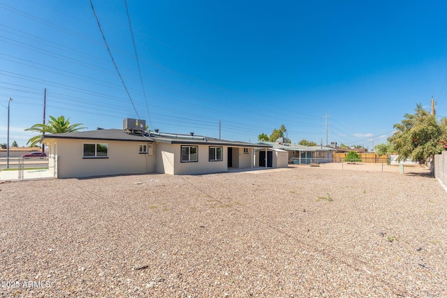 rear view of house featuring a fenced backyard and central AC unit