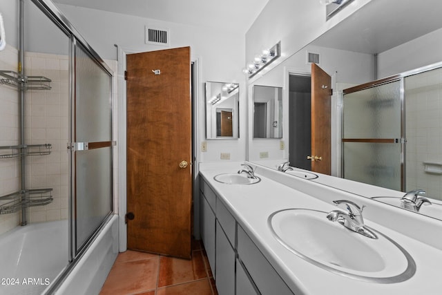 bathroom with enclosed tub / shower combo, double sink, vanity with extensive cabinet space, and tile flooring