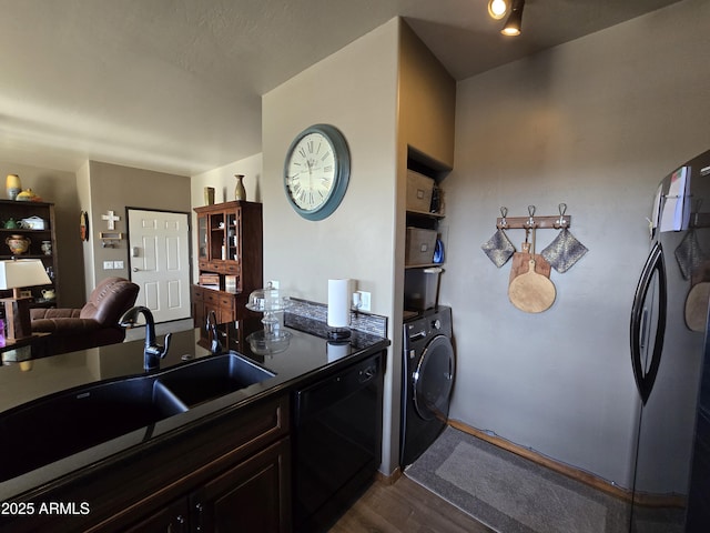 kitchen featuring dark brown cabinetry, washer / dryer, sink, dark hardwood / wood-style floors, and black dishwasher