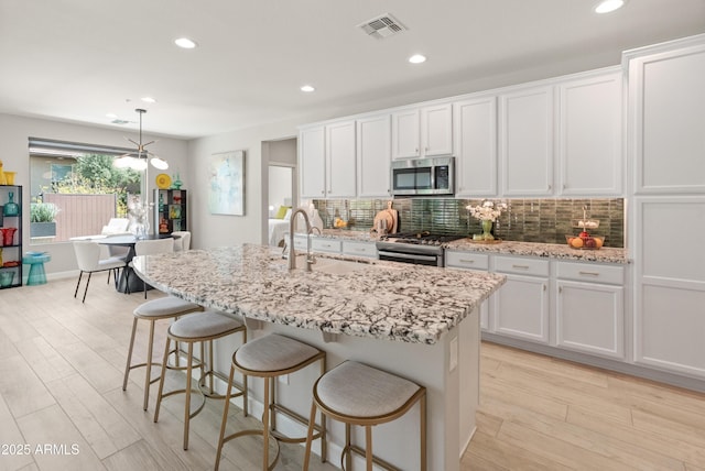 13186 W Via Dona Rd, Peoria, AZ 85383 - kitchen with appliances with stainless steel finishes, a sink, decorative backsplash, recessed lighting, and light wood-type flooring