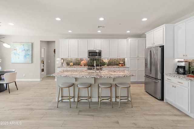 13186 W Via Dona Rd, Peoria, AZ 85383 - kitchen with appliances with stainless steel finishes, decorative backsplash, recessed lighting, a sink, and a kitchen island with sink