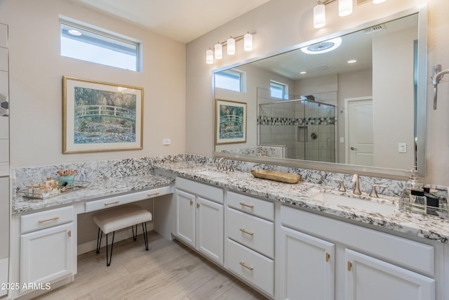13186 W Via Dona Rd, Peoria, AZ 85383 - bathroom featuring plenty of natural light, a stall shower, double vanity, and wood finished floors