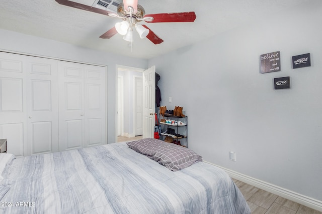 bedroom featuring ceiling fan, a closet, and light hardwood / wood-style flooring