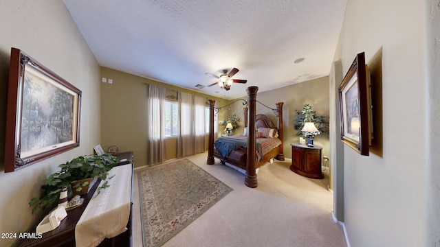 bedroom with ceiling fan, carpet floors, and a textured ceiling