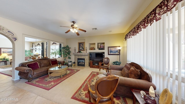 living room featuring ceiling fan with notable chandelier and light tile patterned floors