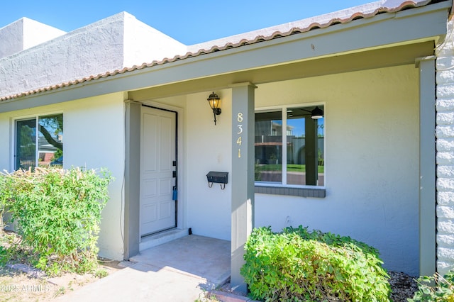 8341 E Keim Dr, Scottsdale, AZ 85250 - view of exterior entry featuring stucco siding and a tile roof