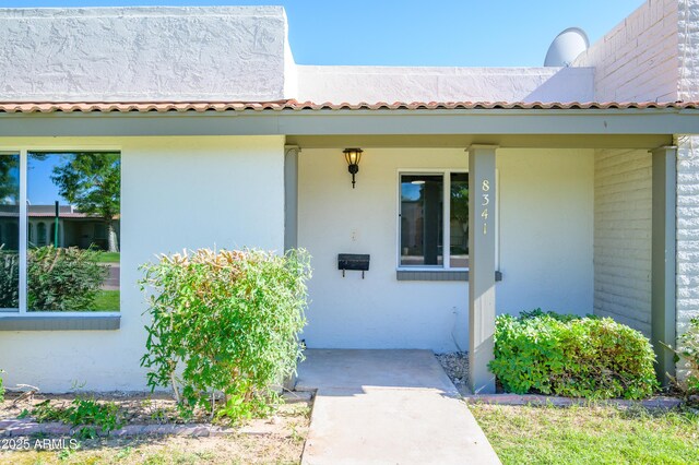 8341 E Keim Dr, Scottsdale, AZ 85250 - view of exterior entry featuring stucco siding and a porch