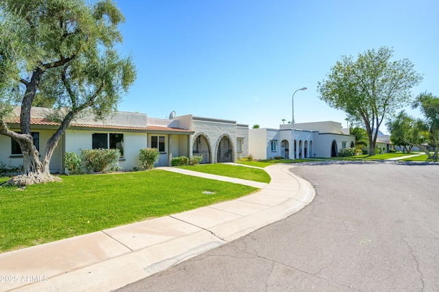 8341 E Keim Dr, Scottsdale, AZ 85250 - view of front facade with stucco siding, a tiled roof, and a front lawn