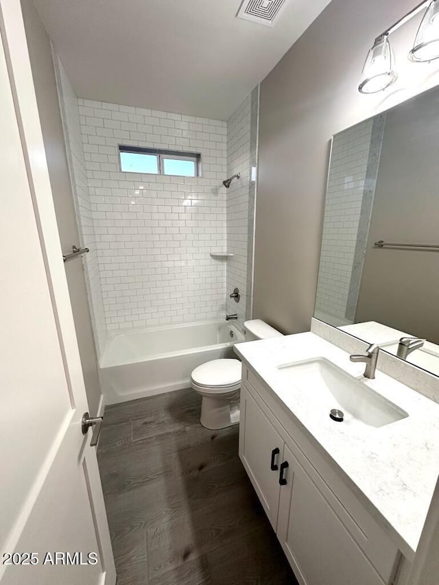 2734 N Trevino Pl, Mesa, AZ 85215 - bathroom with visible vents, toilet, wood finished floors, vanity, and shower / bathing tub combination