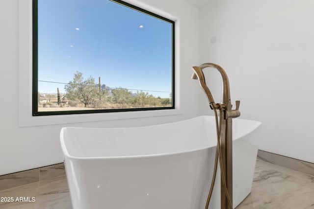 bathroom with a healthy amount of sunlight and a bath