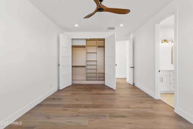 unfurnished bedroom with connected bathroom, ceiling fan, a closet, and light hardwood / wood-style floors