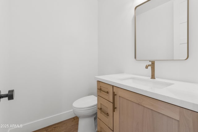 bathroom featuring hardwood / wood-style flooring, vanity, and toilet