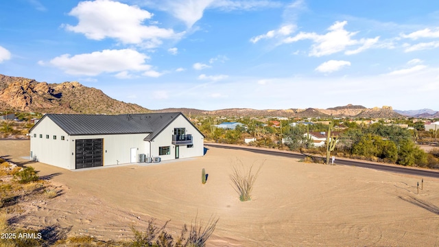 view of home's exterior with a mountain view, a garage, and a balcony