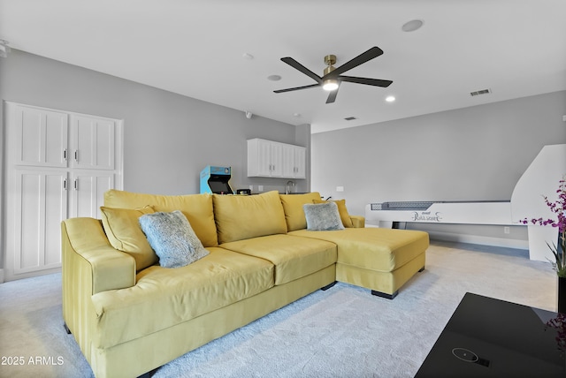 living room featuring light carpet and ceiling fan