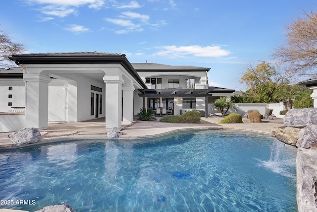 rear view of house with a patio area and a balcony