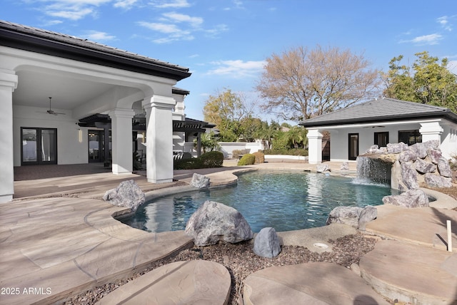 view of swimming pool featuring pool water feature, ceiling fan, and a patio area