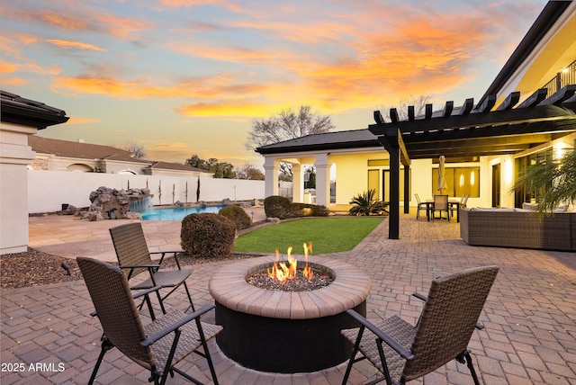 patio terrace at dusk featuring a fenced in pool and an outdoor fire pit