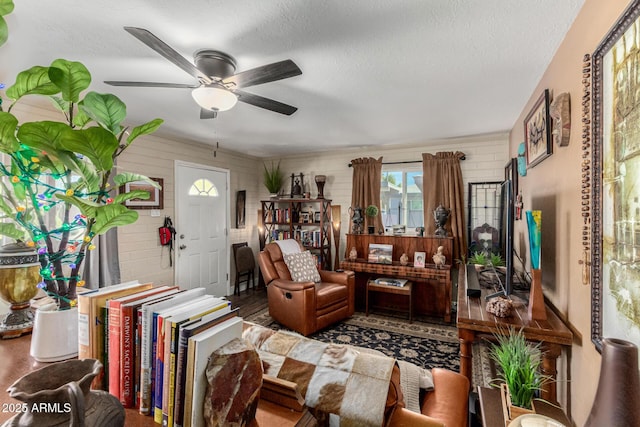 living area with ceiling fan and a textured ceiling