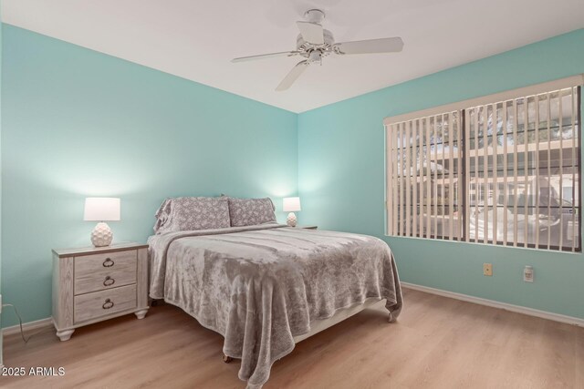 bedroom featuring wood finished floors, a ceiling fan, and baseboards